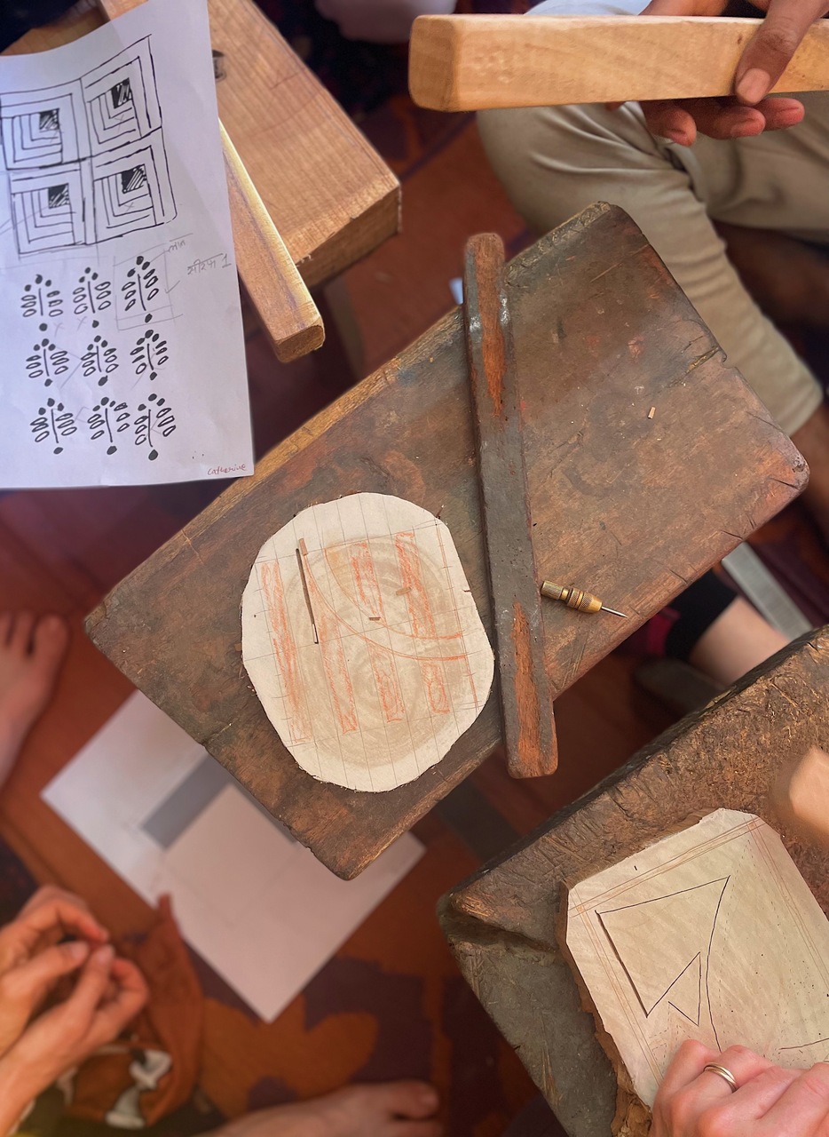 Intricately detailed drawings can be seen on the paper, exhibiting the careful craftsmanship of an wood block carver.