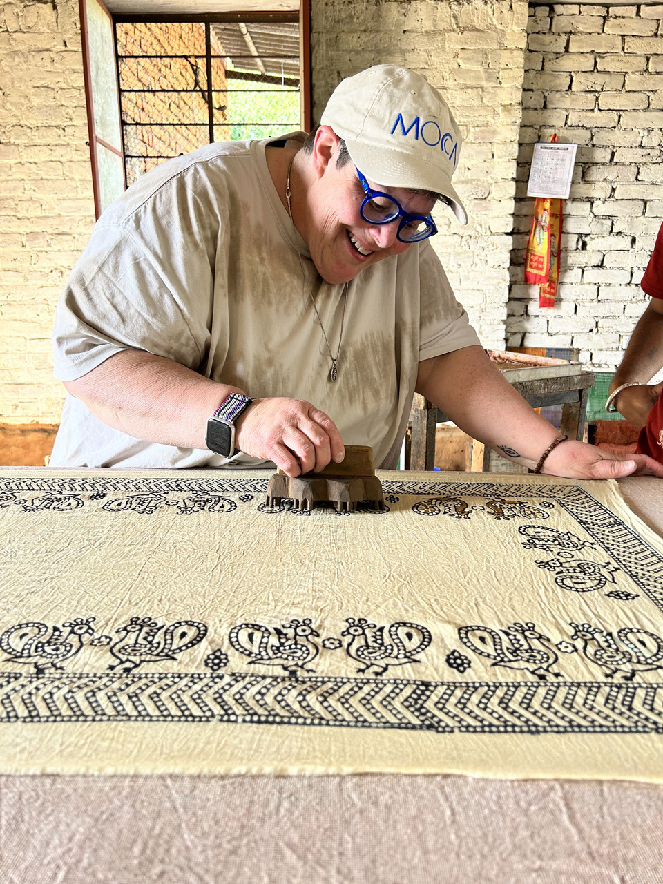 A woman in the process of completing her block printed pattern.