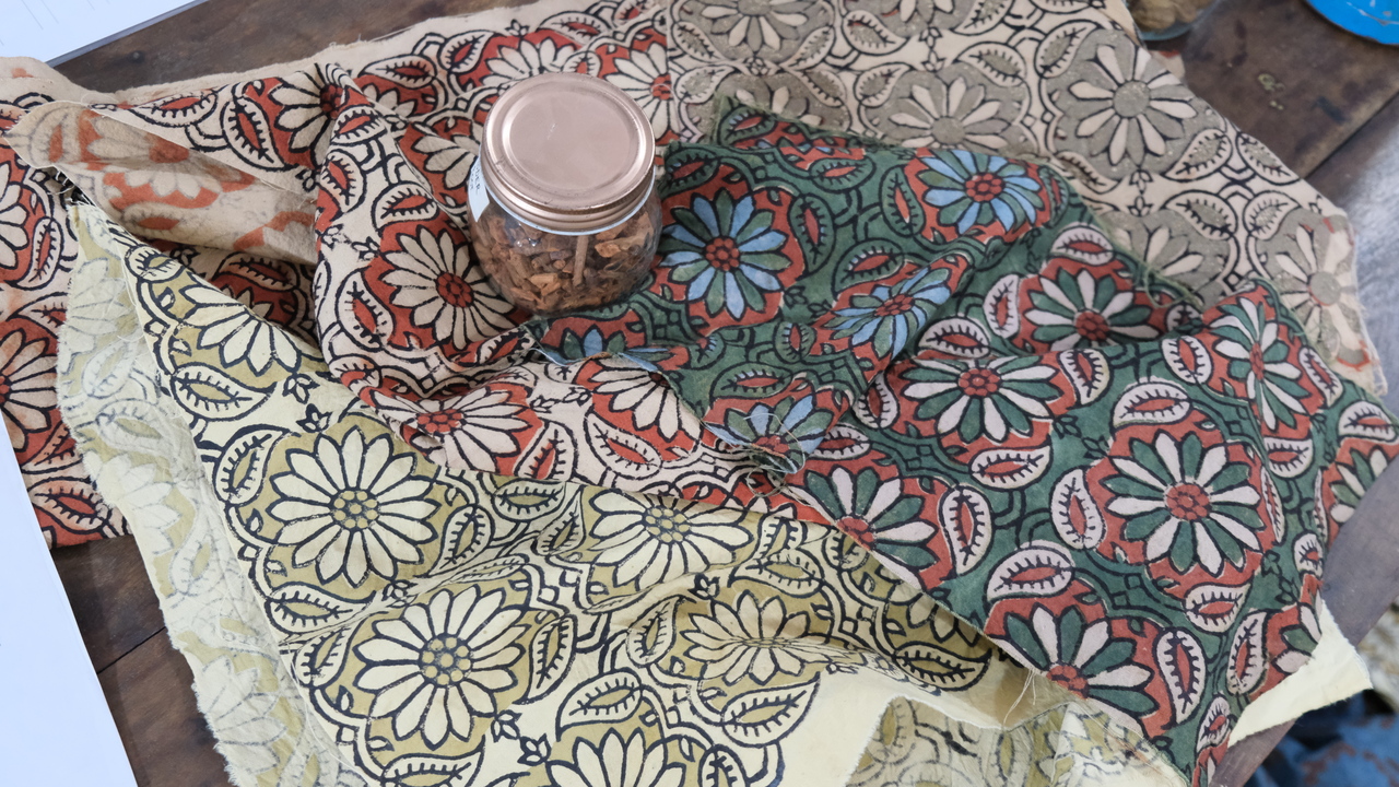 Floral block print designed fabric with a variety of color variations placed on the table.