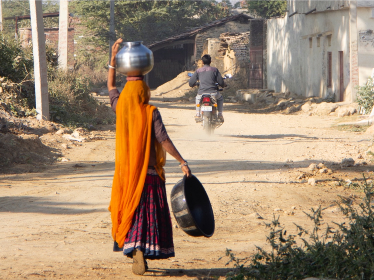 A women walking back home after collecting the water for the day in her gharvi (stencil)