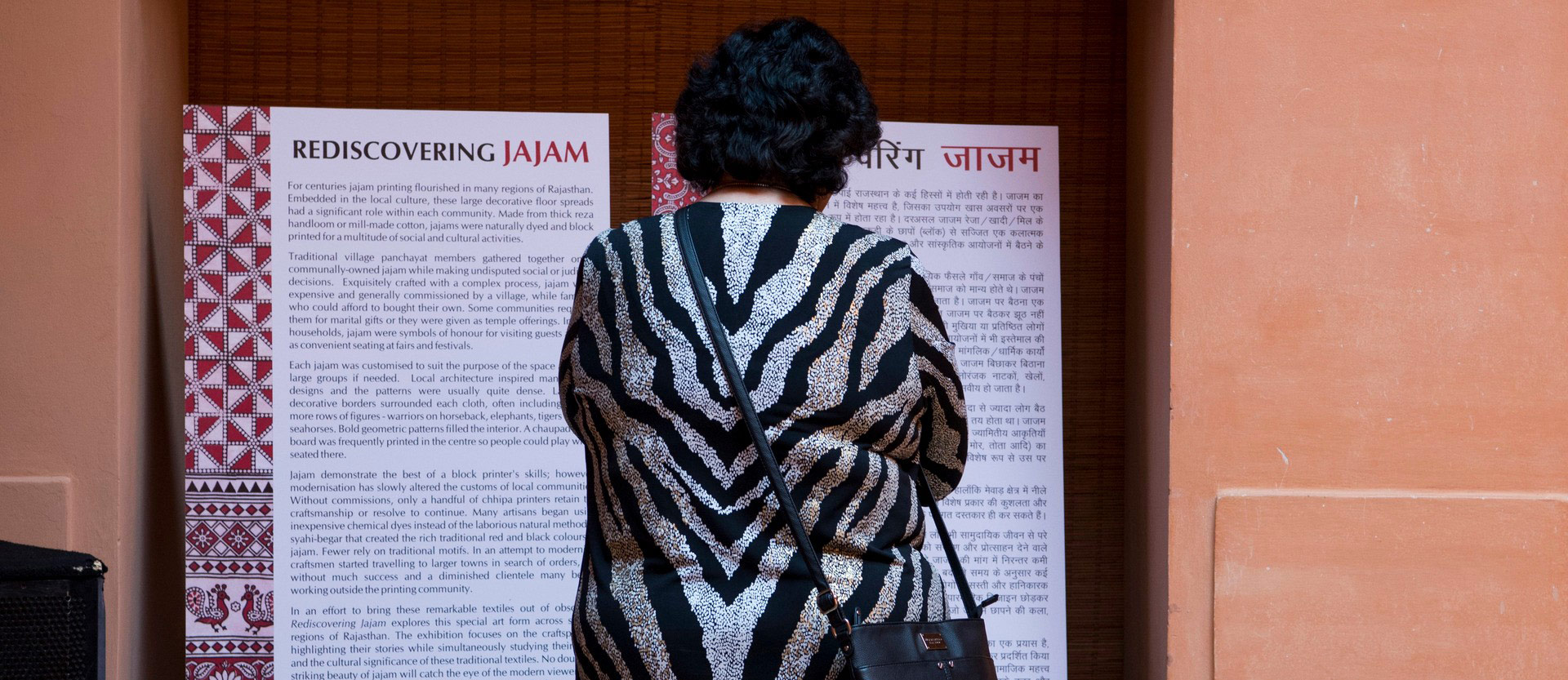 a woman reads the informational standees at the museum exhibit
